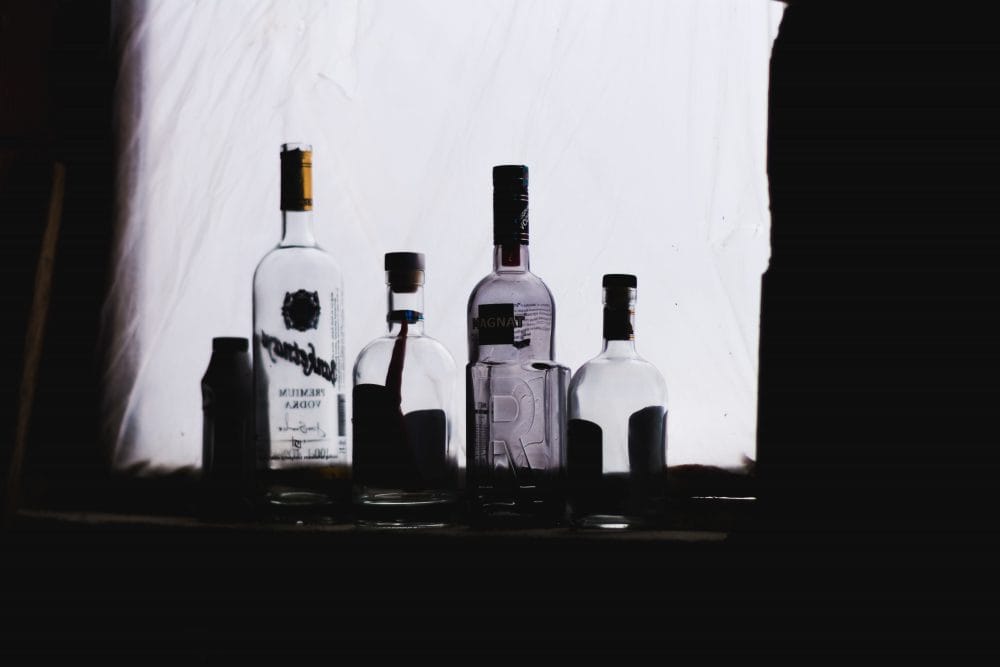 empty alcohol bottles line a windowsill
