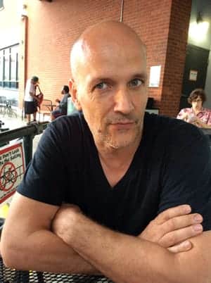 piers man with arms crossed defensively at restaurant in need of addiction recovery