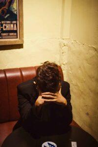 person with head in hands at cafe table
