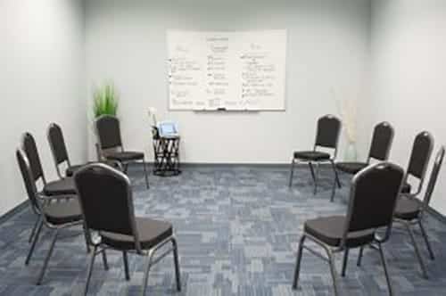 chairs circled in a meeting room with whiteboard