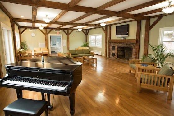 piano, seats, fireplace, tv of green mountain treatment center common area