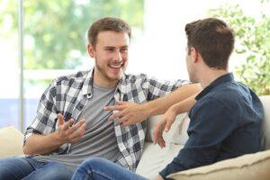 two male patients talk outside at a men's rehab center