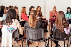 a large group of women sit and talk at a womens rehab center