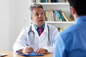 concerned doctor talks to male patient in a codeine detox center