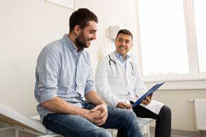male doctor shows male patient a chart on a clipboard at a mens detox center