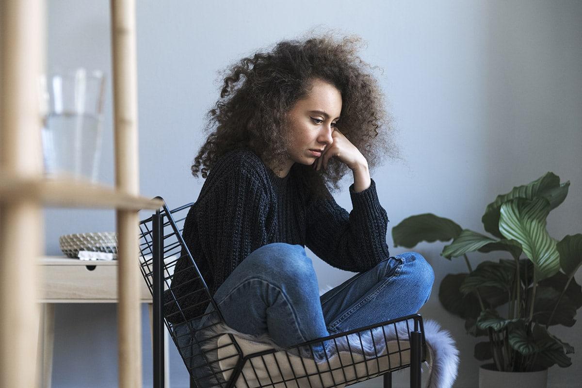 woman sitting in chair showing signs of drug relapse