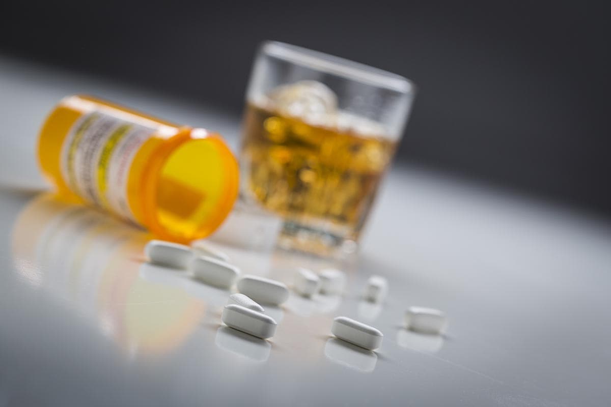 Alcohol and pills on table about to be taken showing what is polysubstance abuse and polysubstance abuse definition