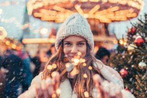 sober christmas, woman staring at you holding up a sparkler at an outdoor christmas event