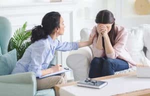what is dual diagnosis, woman in therapy being comforted by therapist