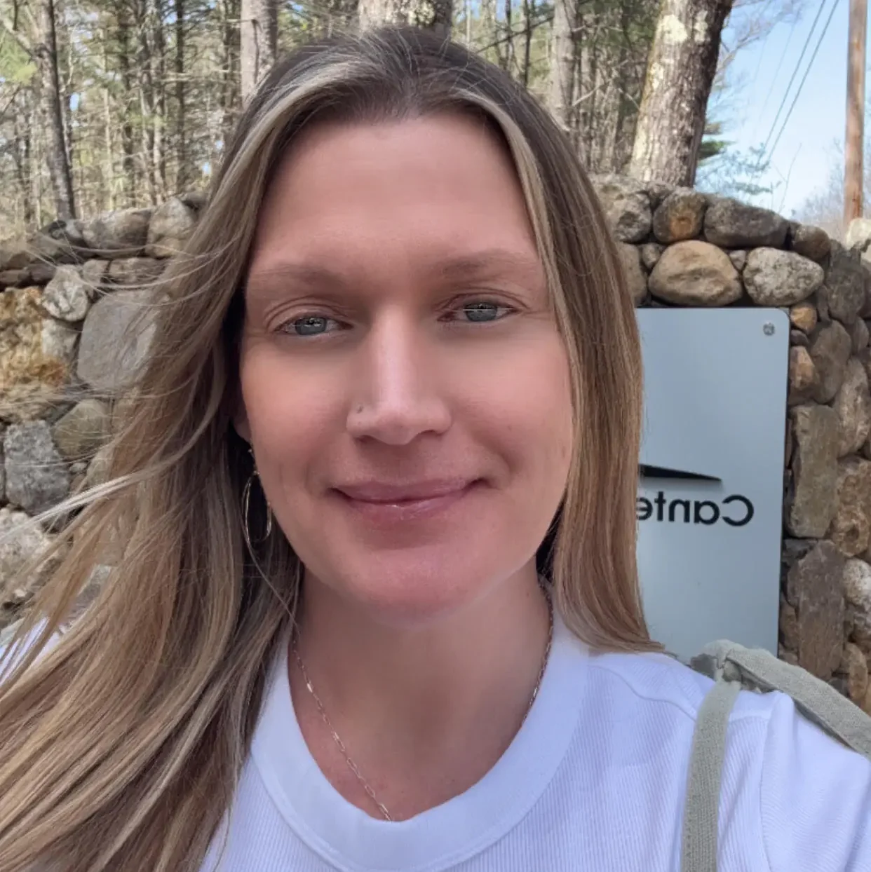 Clinician smiling outdoors by Canterbury Inpatient Care sign